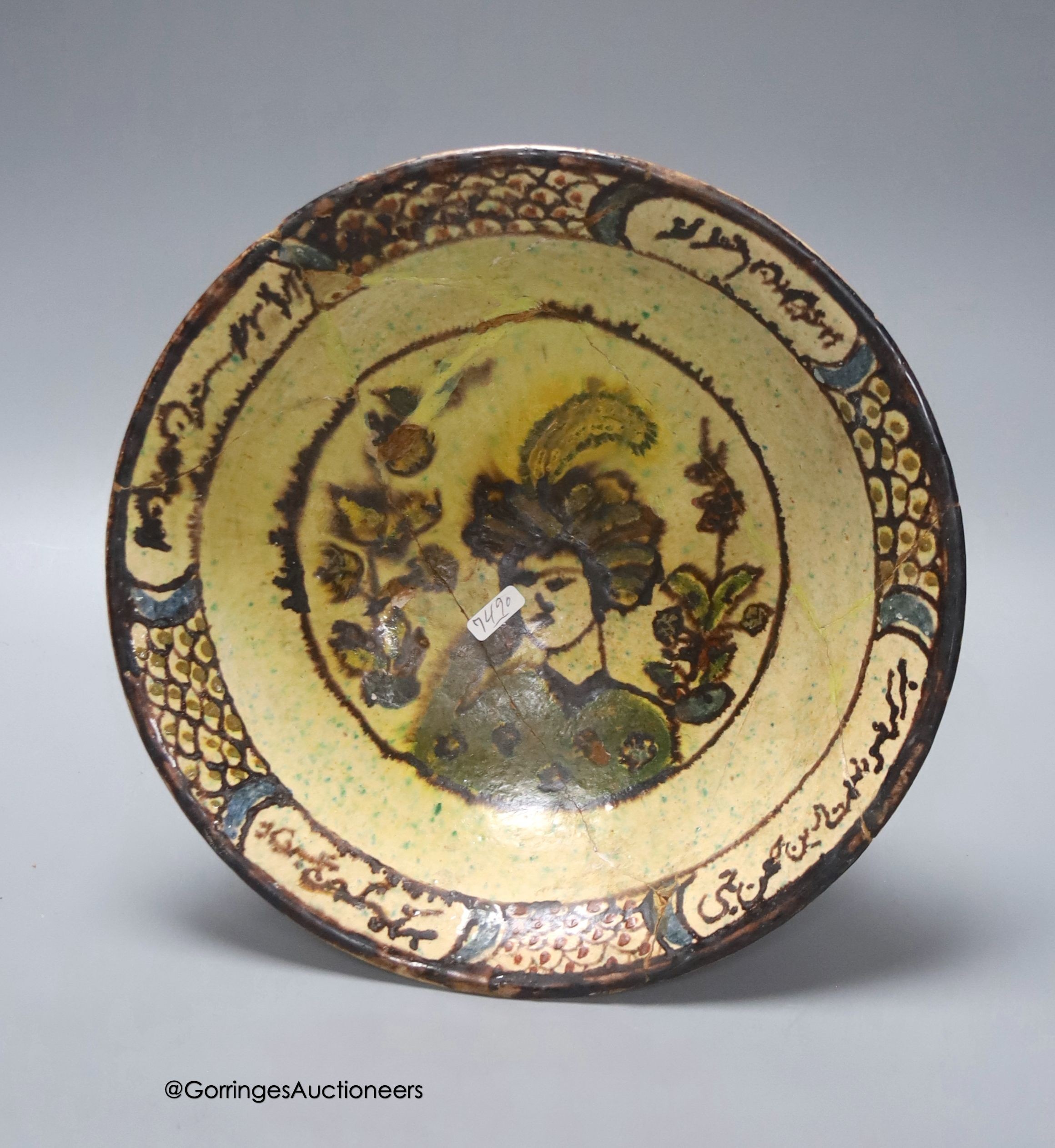 An Islamic bowl with central figure and scripted border, diameter 26cm (a.f.)